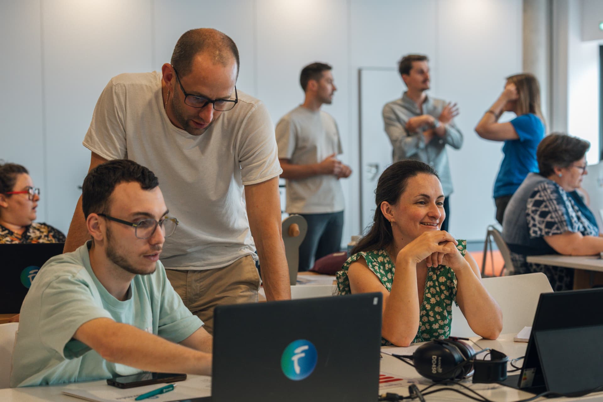 Participants échangeant autour de leurs ordinateurs pendant l'atelier